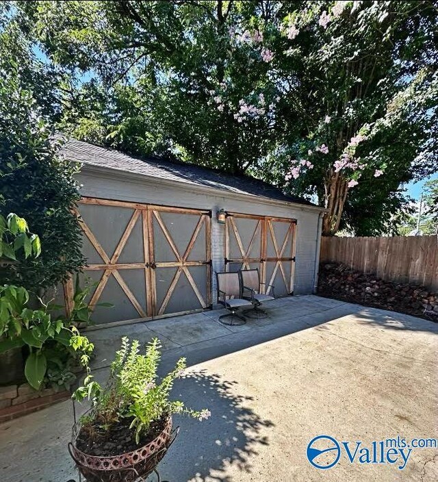 view of outdoor structure featuring an outbuilding and fence