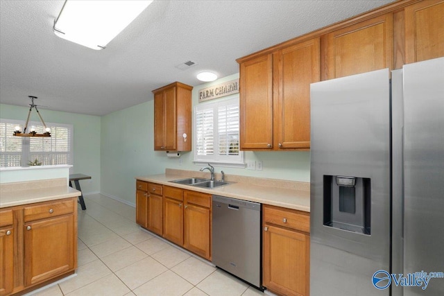 kitchen with pendant lighting, sink, a healthy amount of sunlight, and appliances with stainless steel finishes