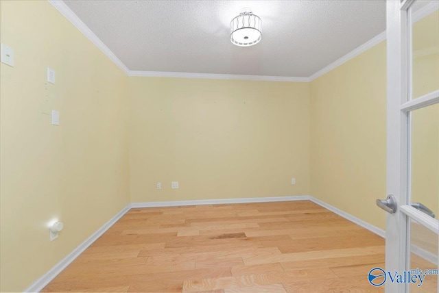 spare room featuring ornamental molding, wood-type flooring, and a textured ceiling