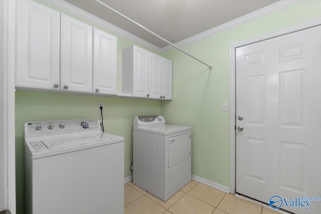 laundry area with light tile patterned floors, cabinets, independent washer and dryer, ornamental molding, and a textured ceiling