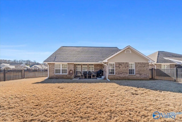 rear view of property featuring a patio area and a lawn