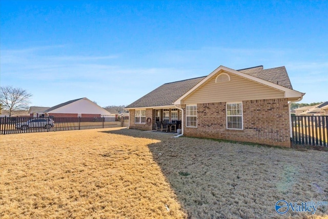 back of house featuring a lawn and a patio