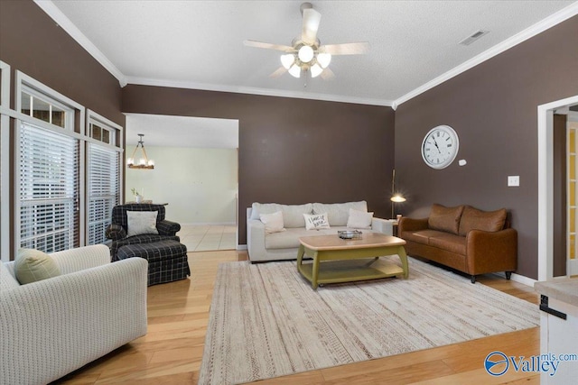 living room featuring hardwood / wood-style flooring, ceiling fan with notable chandelier, ornamental molding, and a textured ceiling