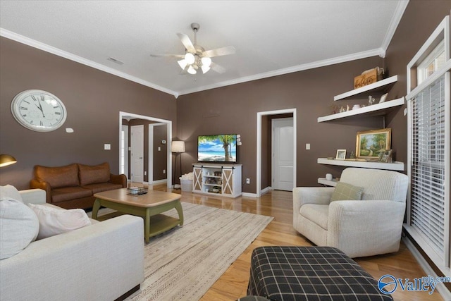 living room with ceiling fan, ornamental molding, and light wood-type flooring