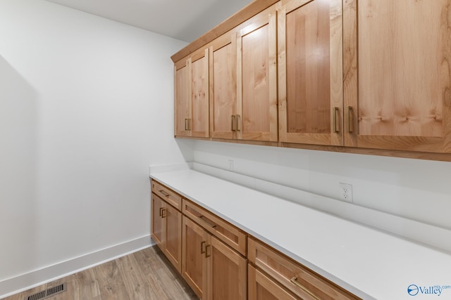 interior space featuring light wood-style flooring, visible vents, and baseboards