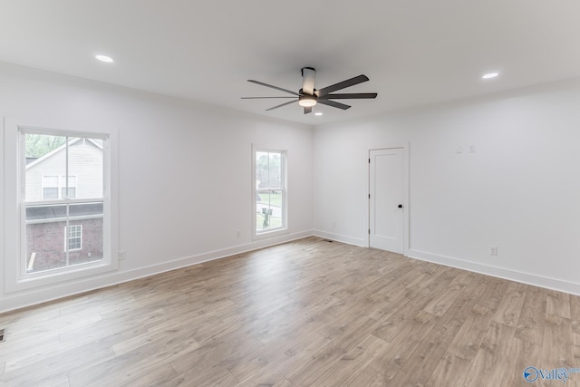 unfurnished room featuring light wood-style flooring, a wealth of natural light, and baseboards