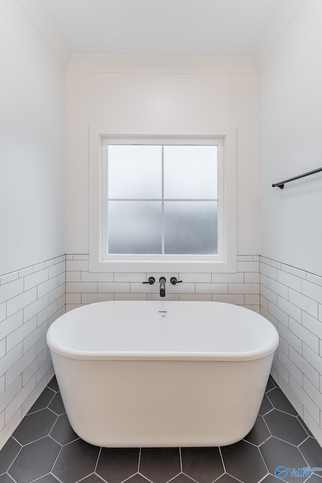 full bathroom featuring a freestanding tub, a wealth of natural light, and tile patterned floors