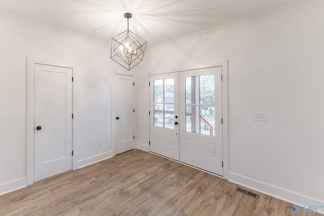 entrance foyer featuring light wood-style flooring, visible vents, baseboards, french doors, and crown molding