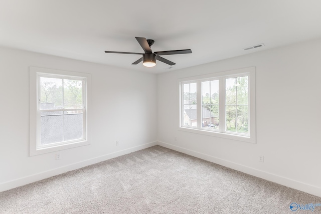 unfurnished room with light carpet, baseboards, visible vents, and ceiling fan