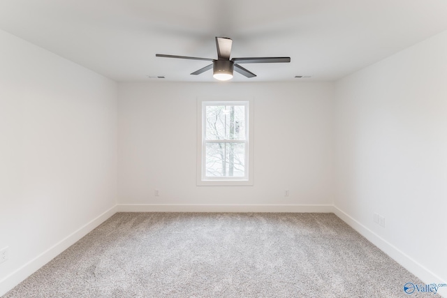 carpeted spare room with ceiling fan, visible vents, and baseboards