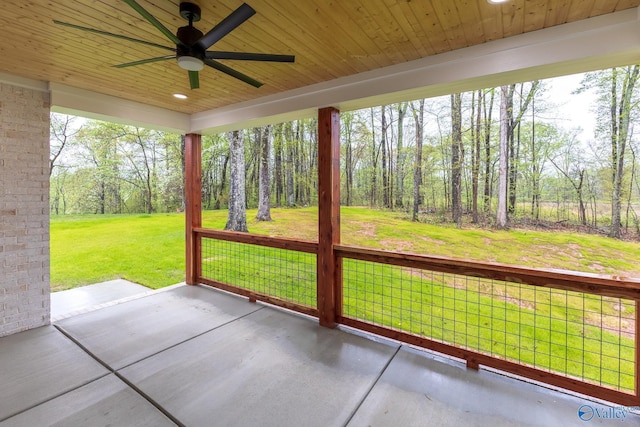 unfurnished sunroom with wooden ceiling, a ceiling fan, and a healthy amount of sunlight