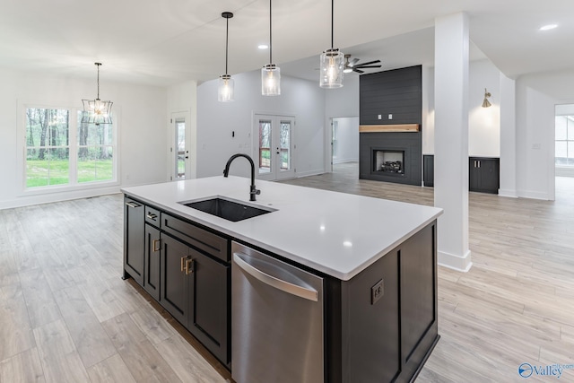 kitchen with dishwasher, open floor plan, a sink, and light countertops