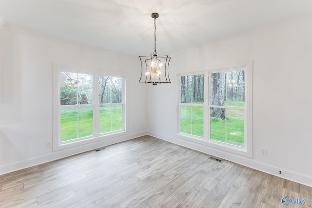 unfurnished room with light wood finished floors, baseboards, visible vents, and an inviting chandelier