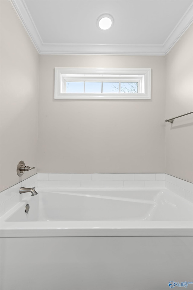 bathroom featuring ornamental molding, a healthy amount of sunlight, and a bath