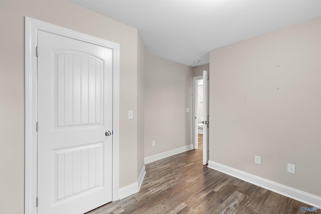 unfurnished bedroom with dark wood-type flooring