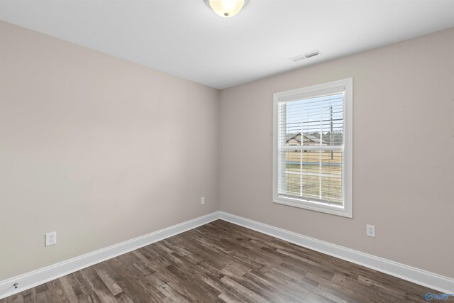 spare room with dark wood-type flooring