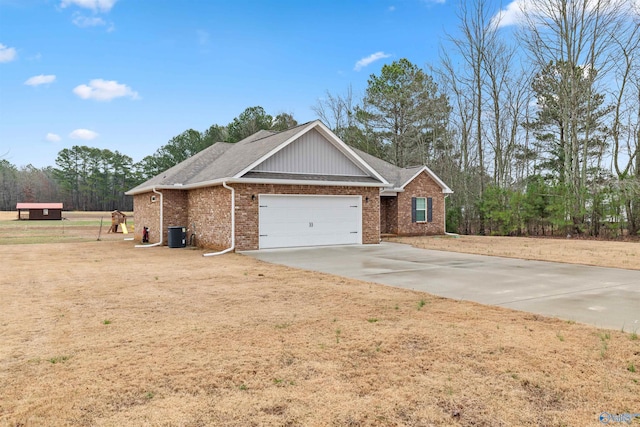 view of front of property featuring central AC unit, a garage, and a front lawn