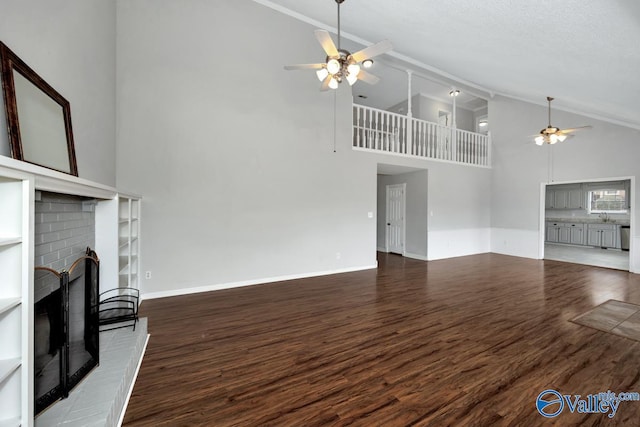 unfurnished living room featuring dark wood-type flooring, ceiling fan, a fireplace, and vaulted ceiling