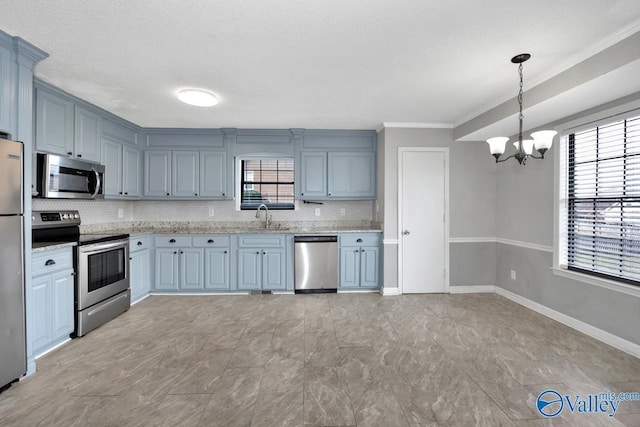 kitchen featuring stainless steel appliances, decorative light fixtures, sink, and plenty of natural light