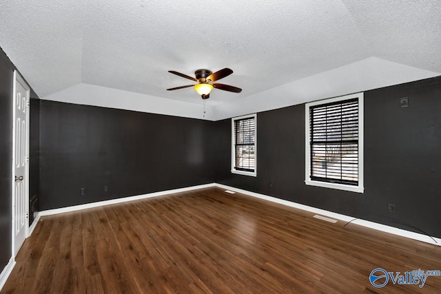 unfurnished room with vaulted ceiling, ceiling fan, hardwood / wood-style floors, and a textured ceiling