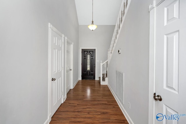 entryway with high vaulted ceiling and dark hardwood / wood-style floors