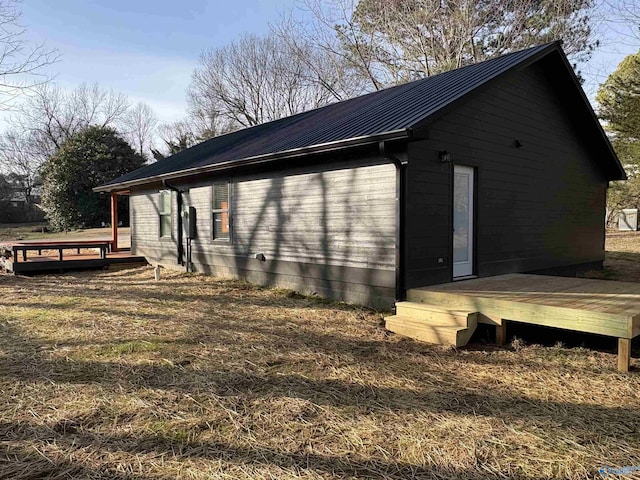 view of side of home featuring a deck and metal roof