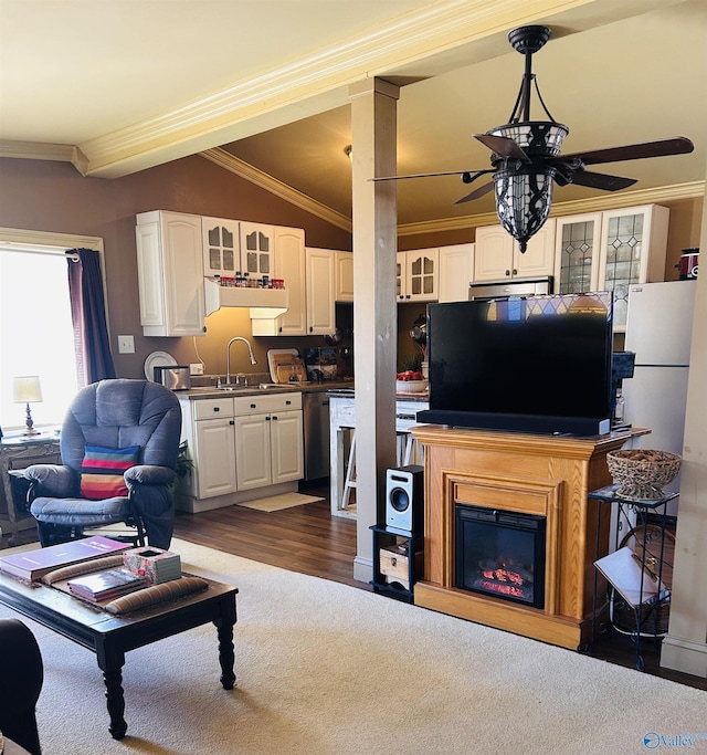 living area with a glass covered fireplace, lofted ceiling, ceiling fan, ornamental molding, and dark wood-style flooring