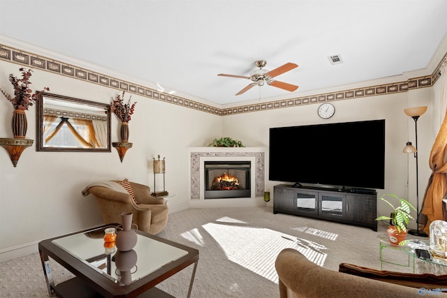 living room with light carpet, crown molding, ceiling fan, and a premium fireplace