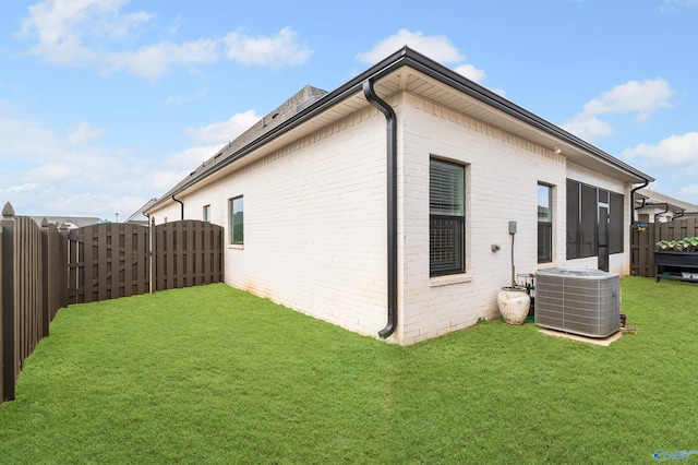 rear view of house with a yard and central AC