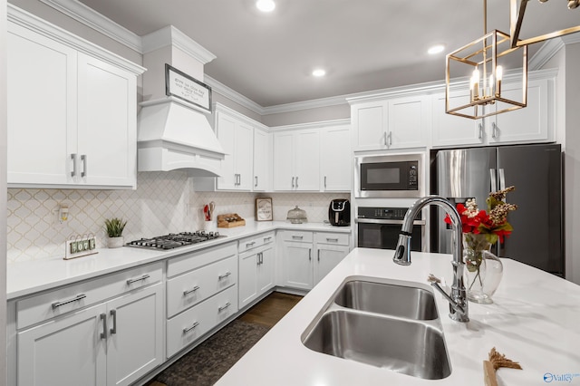 kitchen with sink, white cabinetry, decorative light fixtures, appliances with stainless steel finishes, and decorative backsplash