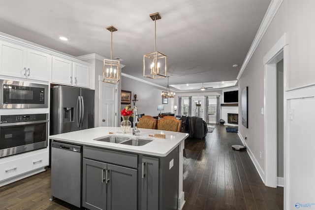 kitchen featuring gray cabinets, white cabinetry, an island with sink, sink, and stainless steel appliances