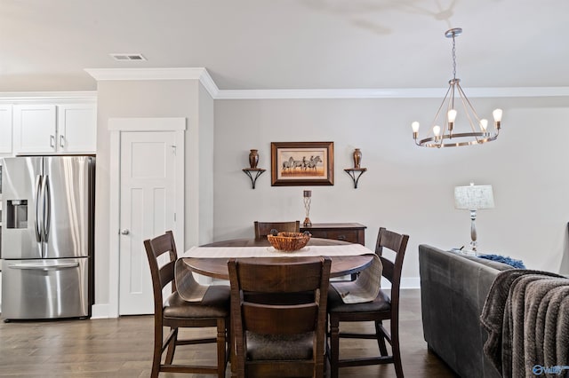 dining area with ornamental molding, dark wood-type flooring, and a notable chandelier