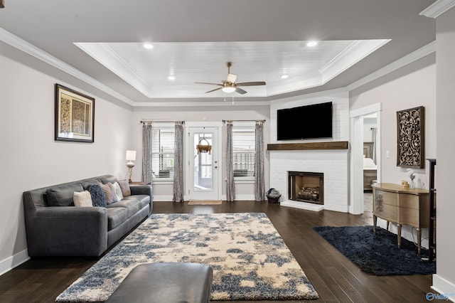 living room featuring crown molding, ceiling fan, dark hardwood / wood-style flooring, and a tray ceiling