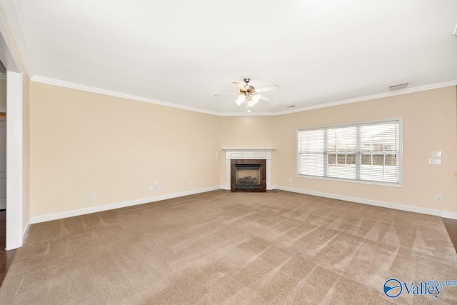 unfurnished living room with baseboards, ornamental molding, a tiled fireplace, a ceiling fan, and carpet