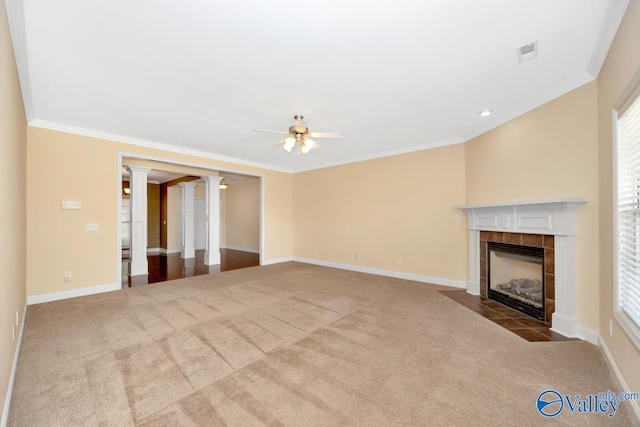 unfurnished living room featuring carpet flooring, ornate columns, a ceiling fan, and crown molding