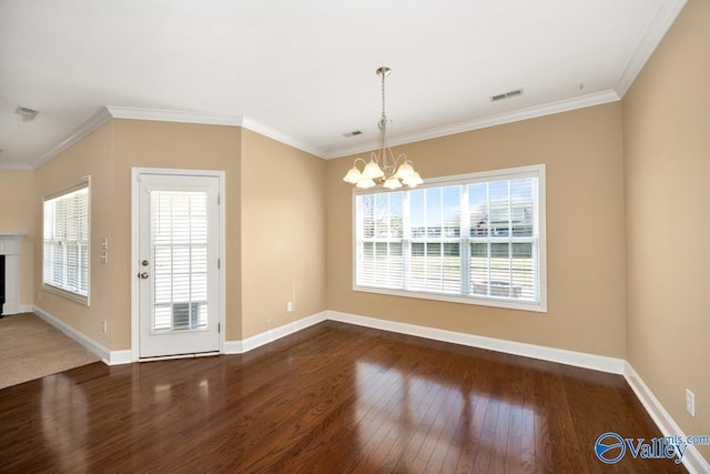 unfurnished dining area featuring ornamental molding, visible vents, a chandelier, hardwood / wood-style floors, and baseboards