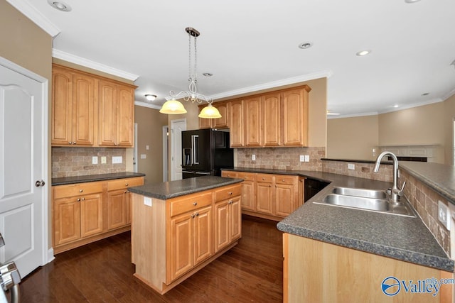 kitchen featuring dark wood-style flooring, black fridge, dark countertops, decorative backsplash, and a sink