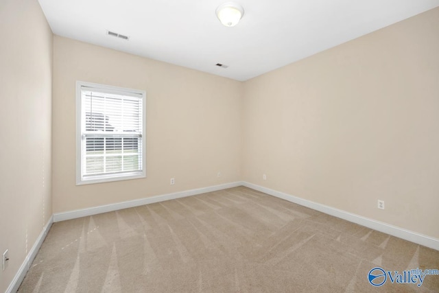 carpeted empty room featuring visible vents and baseboards
