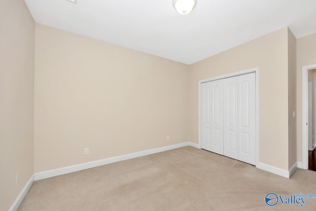 unfurnished bedroom with light carpet and baseboards