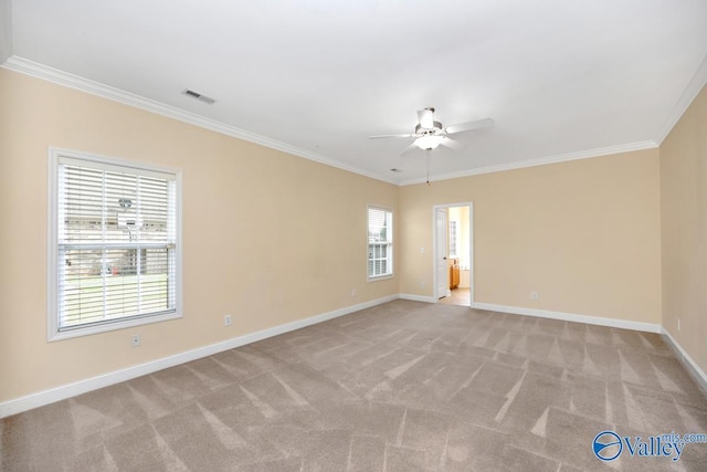 empty room with crown molding, a ceiling fan, visible vents, light carpet, and baseboards