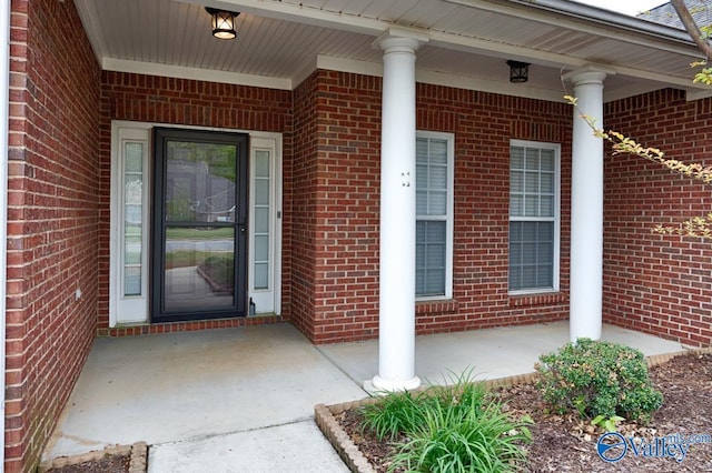 entrance to property with brick siding and covered porch
