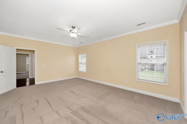 empty room with visible vents, crown molding, and a ceiling fan