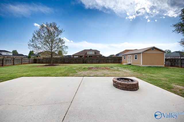 view of patio / terrace with a fenced backyard, an outdoor structure, and an outdoor fire pit
