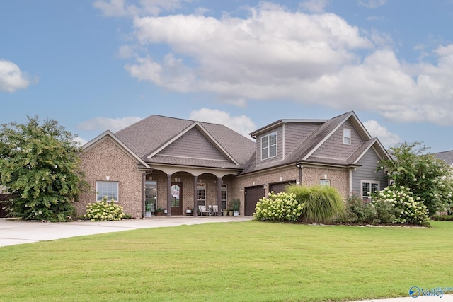 view of front of house with an attached garage, driveway, a front lawn, and brick siding