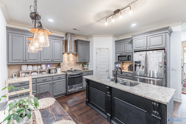 kitchen with wall chimney range hood, dark wood-type flooring, gray cabinets, a sink, and stainless steel appliances