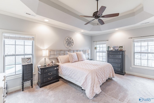 bedroom featuring light colored carpet, visible vents, ornamental molding, and a raised ceiling
