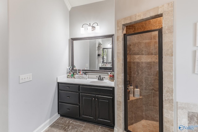 bathroom featuring vanity, ornamental molding, baseboards, and a stall shower