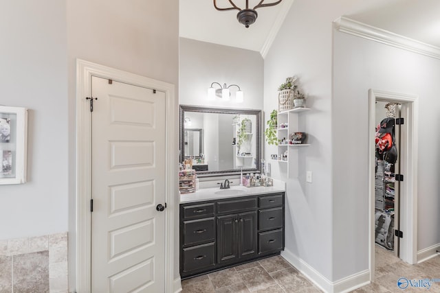 bathroom featuring crown molding, vanity, baseboards, and a closet