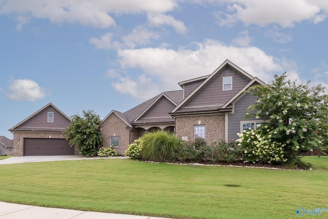 craftsman house featuring a garage, a front yard, driveway, and brick siding