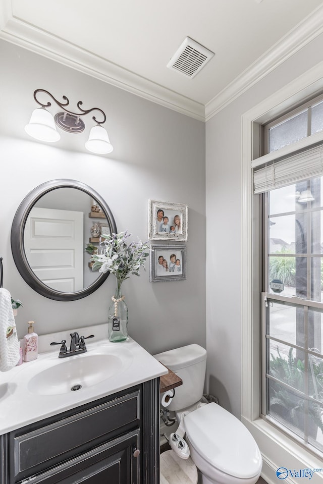 bathroom with visible vents, crown molding, wood finished floors, vanity, and toilet